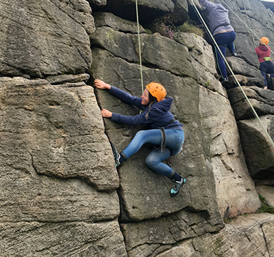 Laying back climbing move at Stanage edge